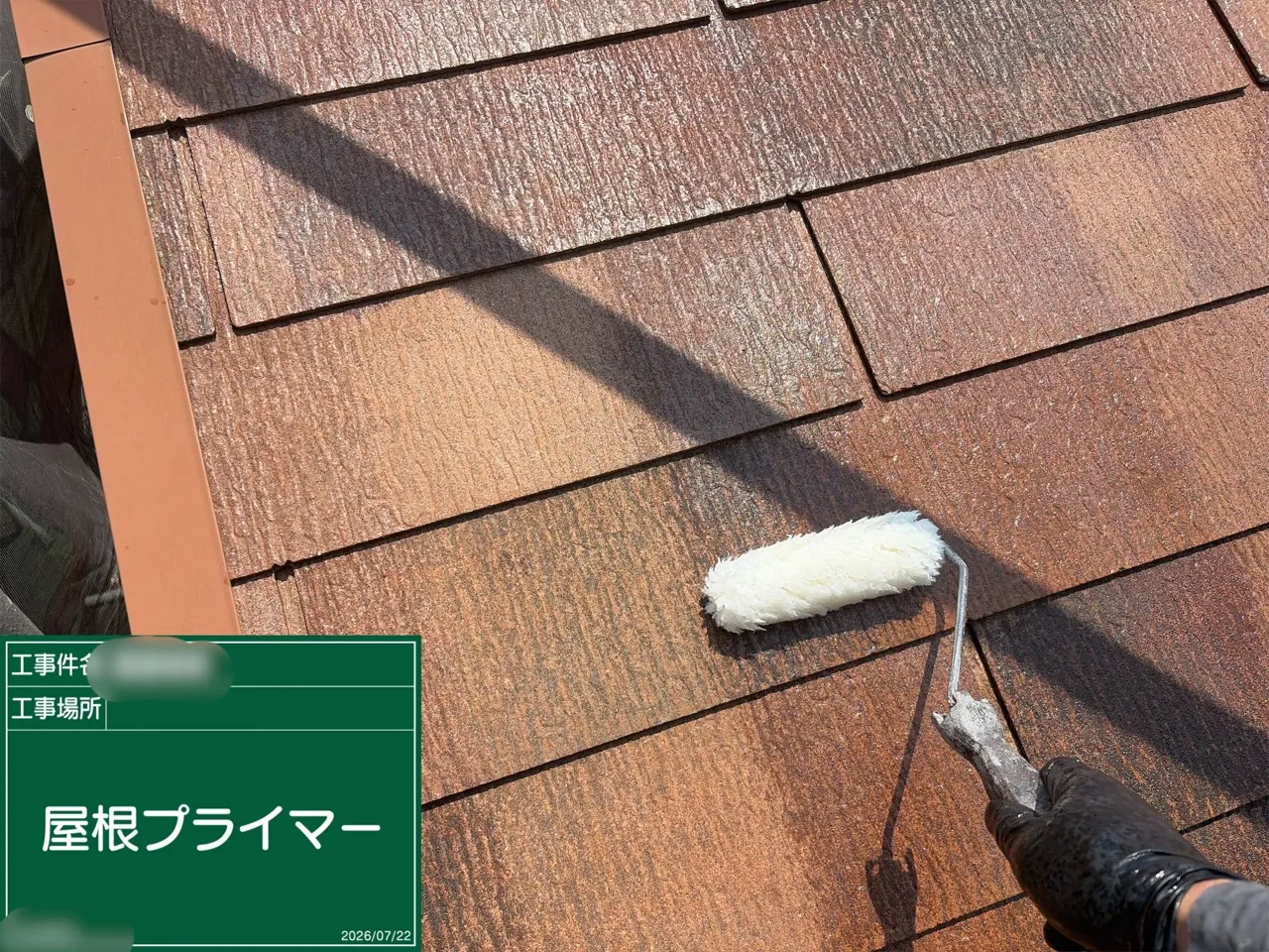 ローラーで屋根材にプライマーを塗る作業