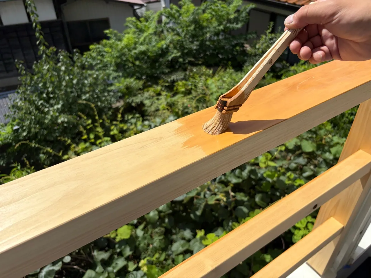 木製ベランダ手すりに防腐剤を塗る作業
