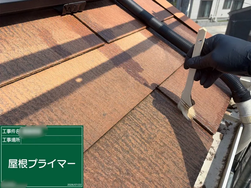 刷毛で屋根材にプライマーを塗る作業