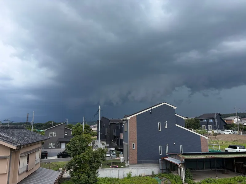 住宅街の西の空に近づく黒い雷雲